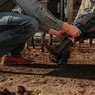Father helping son put on Durango Shyloh western kids boots
