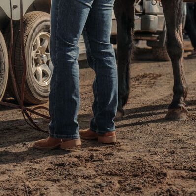 Woman tacking up horse wearing Durango Shyloh western boots