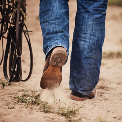 Cowboy walking in arena with DDB0410 western rodeo performance boot