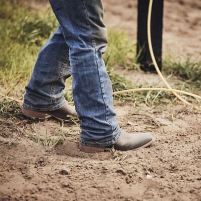 Cowboy walking in arena with DDB0413 western rodeo performance boot