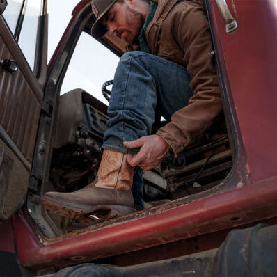 Man in a truck wearing Rebel™ Durango western boots 