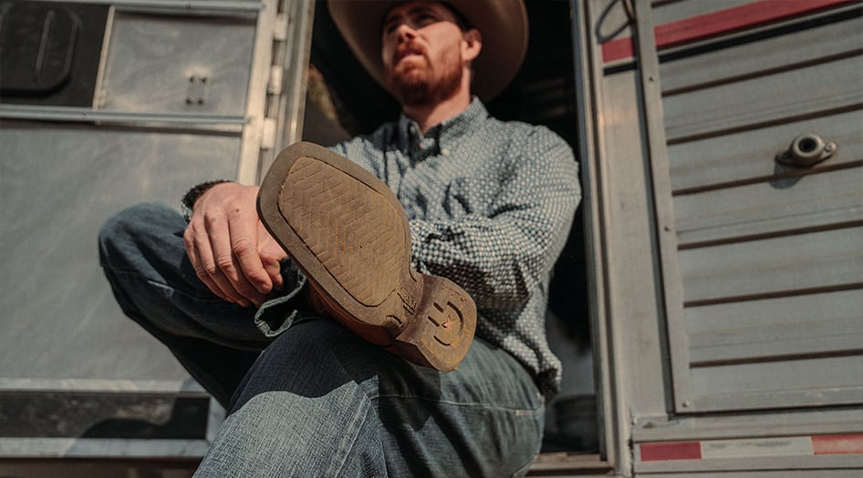 Man wearing Durango Shyloh western boots relaxing on a horse trailer