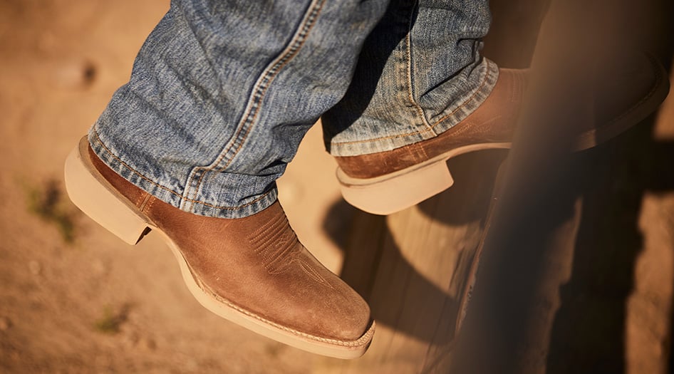 Man pulling jeans over boot