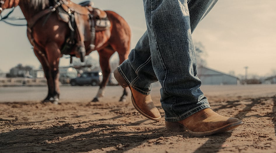 Man wearing Durango Shyloh western boots while walking horse on fairgrounds