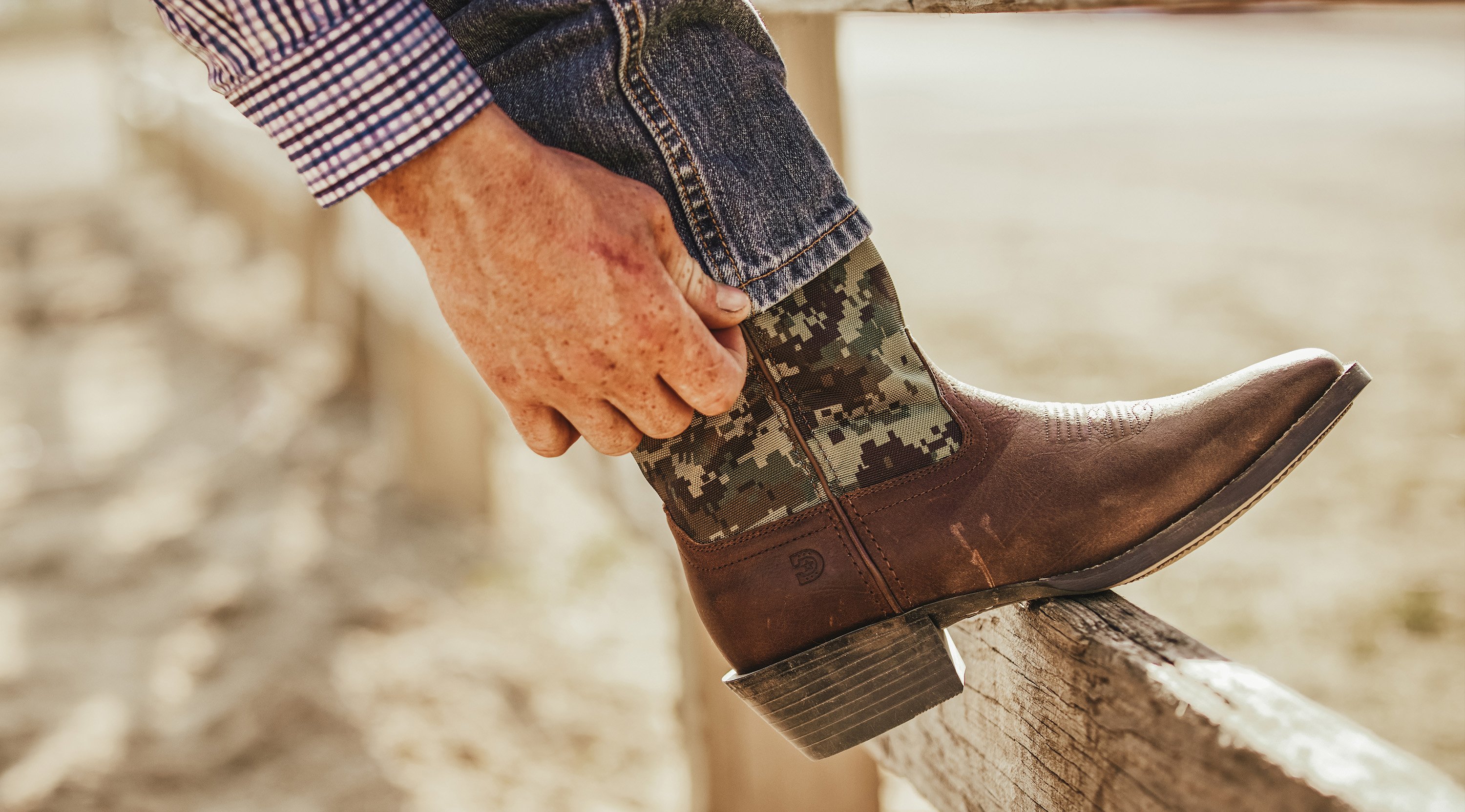 Man pulling jeans over boot