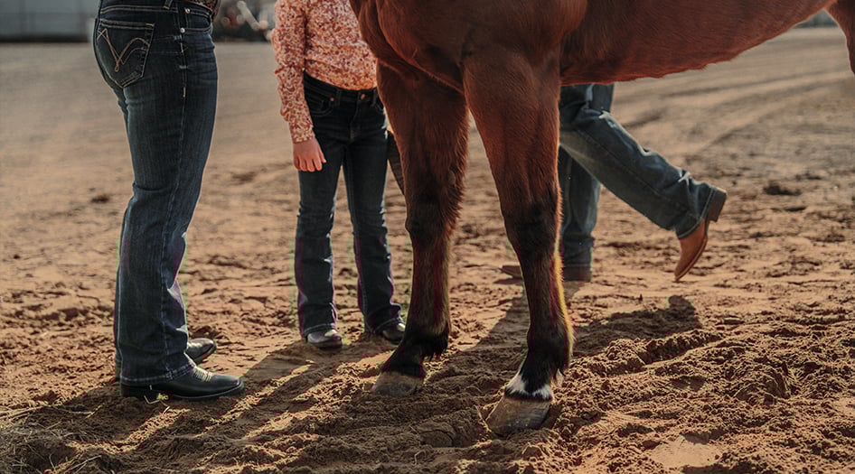 Woman wearing Durango Shyloh western boots while walking horse on fairgrounds